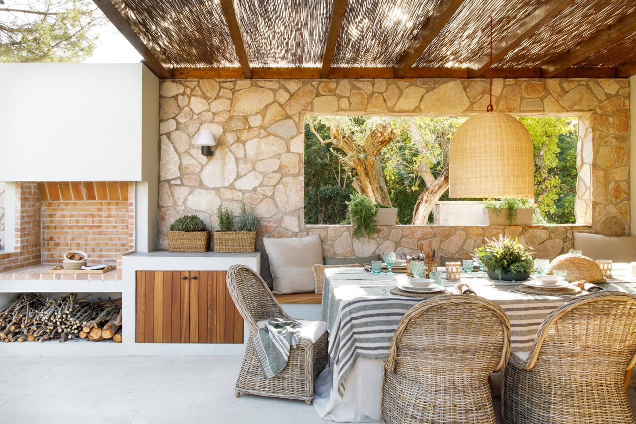 “Een veranda, met een houten structuur en beschermd tegen de regen, verbindt het interieur met de eethoek buiten het landhuis.”